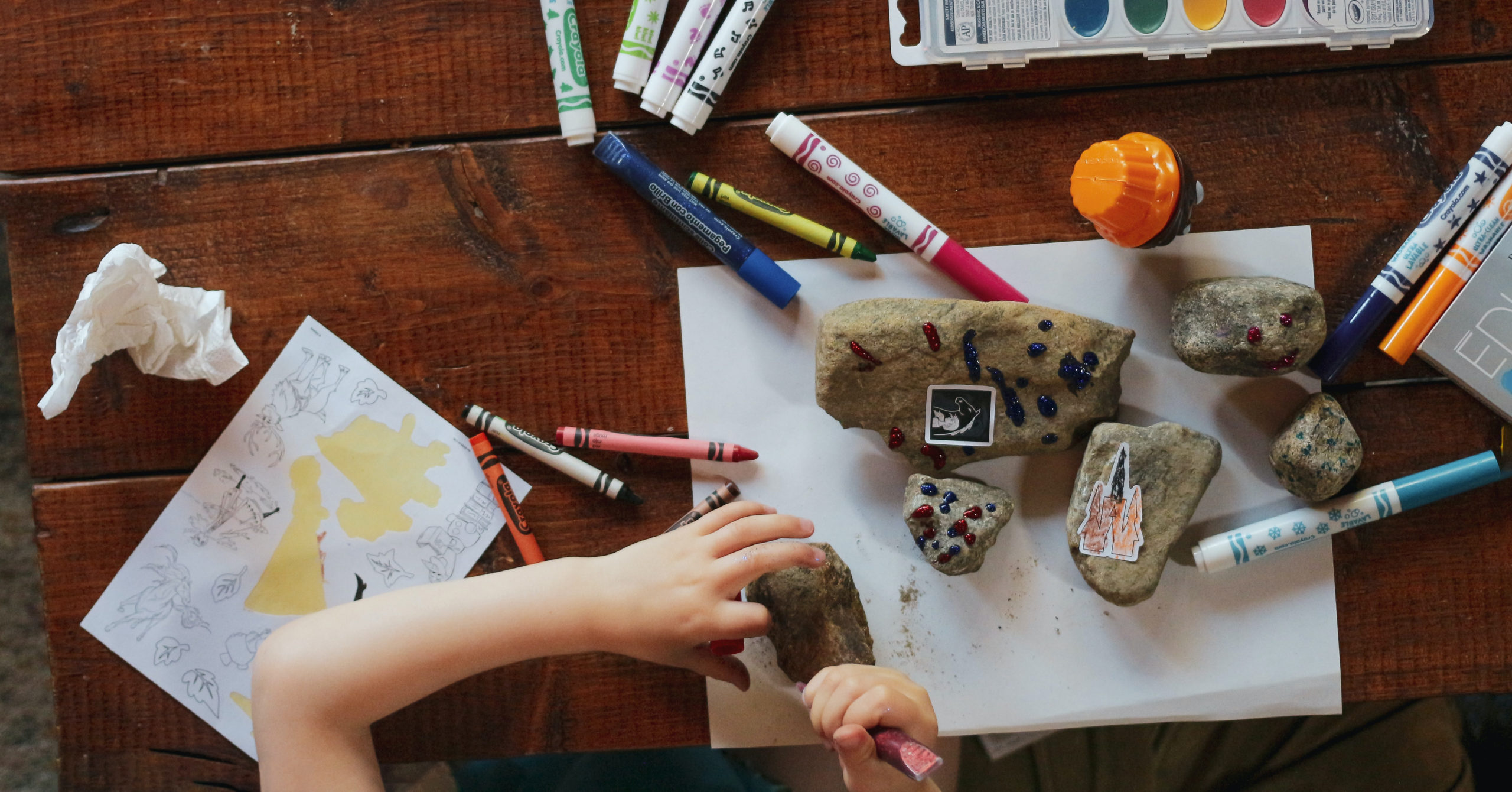 child creating art with rocks